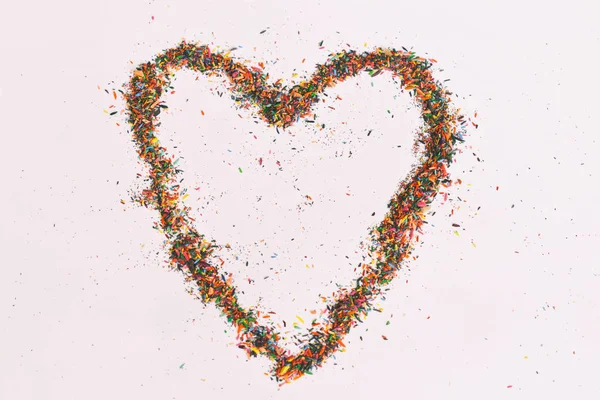 Colorful heart made from shavings of pencils on white background. Ideas with color pencil dust. Copy space.