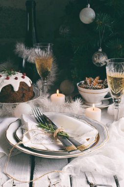 Noel ve yeni yıl tatili masa ayarı. Kutlama. Xmas akşam yemeği yer ayarı. Tatil dekorasyon. Dekor. Şampanya, meyveli pasta plaka, mandalina, gözlüklü