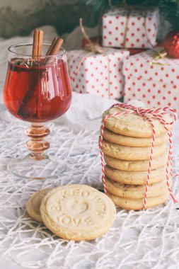 Noel ve yılbaşı tatil kutlama kavramı arka plan. Kupa ile baharat, ev yapımı somun kurabiye, kurabiye, xmas ağacı süsle ahşap masa üzerinde mulled şarap.