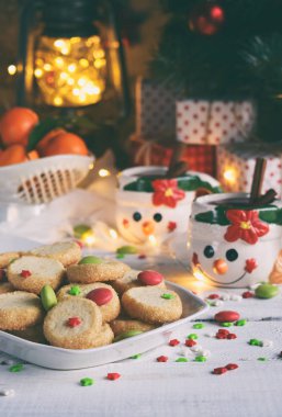 Noel ve yılbaşı tatil kutlama kavramı arka plan. Kupa ile baharat, ev yapımı somun kurabiye, kurabiye, xmas ağacı süsle ahşap masa üzerinde mulled şarap.