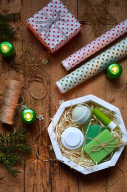 Kozmetik Hediyelik - kaydırma vücut kremi, banyo bomba, sabun, ruj. Hediye kutusu, ambalaj kağıdı, festival dekorasyon ve köknar ağacı dalı ile kompozisyon. Mutlu Noeller ve mutlu yeni yıl kavramı.