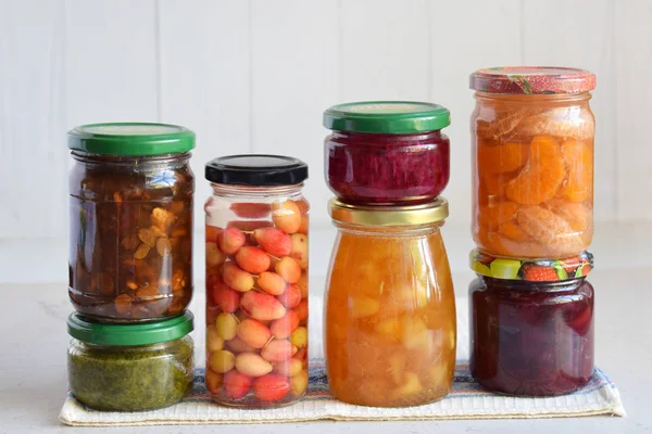 Variety of preserved food in glass jars - pickles, jam, marmalade, sauces, ketchup. Preserving vegetables and fruits. Fermented food. Autumn canning. Conservation of harvest.