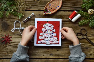 El yapımı Noel tebrik kartı üzerinden kendi elleriyle keçe yapım. Çocuk DIY kavramı. Noel dekorasyon yapma.