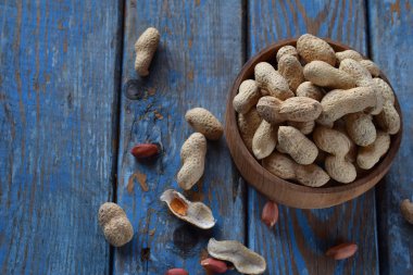 Fındık kabuğu ve ahşap zemin üzerine soyulmuş fıstık fıstık. Diyet ve sağlıklı beslenme. Çiğ gıda