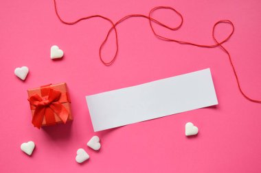 Küçük mevcut kutu pembe bir arka plan üzerinde metniniz için boş bir kağıt ile. Sevgililer günü hediye veya tebrik kartı kavramı
