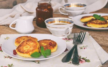 Süzme peynir kızartma yulaf-pul ile krep. Reçel ve ahşap zemin üzerine ekşi krema ile Ukrayna veya Rus syrniki. Geleneksel kahvaltı. Ücretsiz Gluten