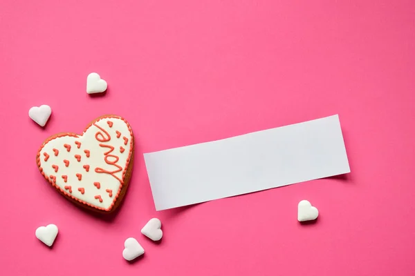 ピンクの背景にテキストの空の紙で手作りジンジャーブレッド心 バレンタイン クッキーの心 食用のバレンタインデー ギフトやグリーティング カードの概念 — ストック写真