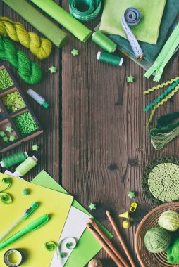 İğne işi ahşap zemin üzerine yeşil aksesuarlar. Örgü, tığ işi, nakış, dikiş. Küçük işletme. Hobi geliri. DIY el yapımı