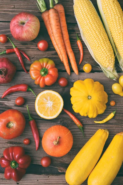 White, green, yellow, orange, red fruits and vegetables on wooden background. Healthy food. Multicolored raw food