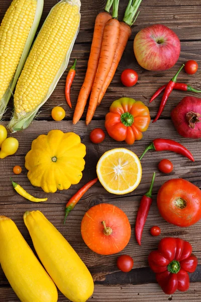 yellow, orange, red fruits and vegetables on wooden background. Healthy food. Multicolored raw food. Copy space.