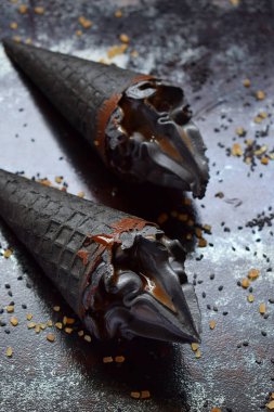 Siyah susam ve siyah gözleme dondurma koni içinde karamel krem buz. Uzay kopyalayın. Trendy Yaz gıda.