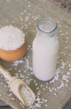 Pirinç sütü şişe, pirinç taneleri ile. Süt alternatif türü. Vegan süt süt. Laktozsuz süt ve süt içecek. Laktoz intoleransı. Sağlıklı gıda.