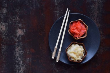 Turşu zencefil dilimleri ve ahşap yemek çubukları. Suşi için madde. Sağlıklı gıda. Geleneksel Japon çeşni