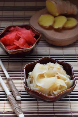Turşu zencefil dilimleri ve ahşap yemek çubukları. Suşi için madde. Sağlıklı gıda. Geleneksel Japon çeşni.