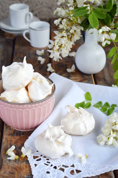 Meringues cookies and cup of coffee. Homemade Meringue kisses drops with acacia flowers. Vintage photo. Copy space. — Stock Photo, Image