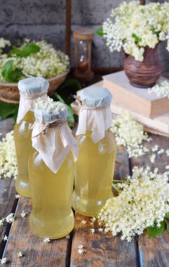 Elderflower samimi şurubu ve çiçeği çiçek ahşap arka plan. Yenilebilir mürver çiçekleri içki ve tatlı lezzet ve aroma ekleyin. Kopya alanı.