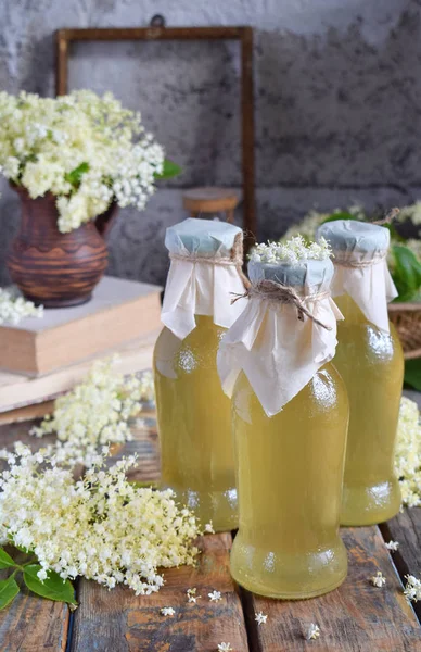 Cordial syrop z kwiatu czarnego bzu i blossom kwiat w drewniane tła. Kwiaty czarnego bzu jadalne dodać aromat i smak do napojów i deserów. Miejsce. — Zdjęcie stockowe