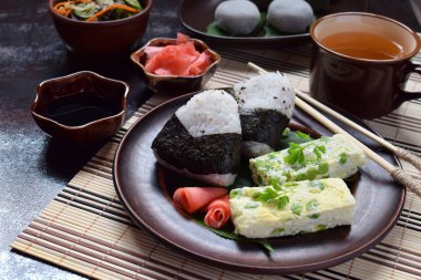 Japon yemekleri - pirinç topları onigiri, omlet, zencefil, sunomono wakame salatalık salatası karışımı. Fasulye ve yeşil çay matcha - jöle yokan, daifuku mochi geleneksel tatlı. Asya kahvaltı ve öğle yemeği