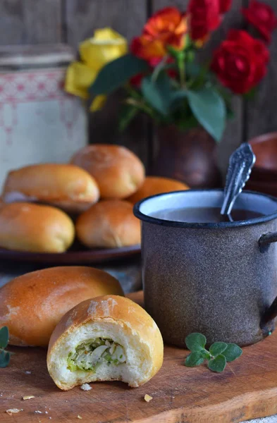 Pasteles con repollo y huevos. Patatas rellenas al horno y una taza de té. Foto rústica. Copiar espacio — Foto de Stock