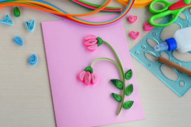 Quilling tekniği. Dekorasyon veya tebrik kartı yapmak. Kağıt şeritler, çiçek, makas. Tatil el yapımı el sanatları: doğum günü, anne veya Babalar günü, Mart 8, düğün. Çocuk DIY kavramı.
