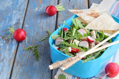 Beslenme çantası taze sebze - roka, turp, beyaz peynir, jambon ve susam ile düz ekmek tortilla salatası ile. Sağlıklı gıda. Beslenme çantası.
