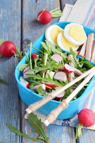 Lunchbox mit Salat aus frischem Gemüse - Rucola, Rettich, Feta-Käse, Schinken und Sesam mit Fladenbrot Tortilla. Gesunde Ernährung. Lunchbox. — Stockfoto