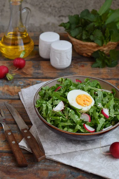 Insalata di vitamina da lattuga, ravanello, cipolle verdi e uova, condita con olio vegetale in piatto su sfondo di legno. Cibo sano. Insalata di verdure verdi fresche — Foto Stock