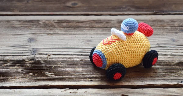 Colored crochet racing car. Toy for babies and toddlers to learn mechanical skills and colors. Handmade crafts. DIY concept. — Stock Photo, Image