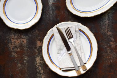 Boş seramik tabaklar ve çatal bıçak takımı. Koyu arka planda sofra takımı. Masa ayarı. Kopya alanı. Mock up, restoran için konsept, menü