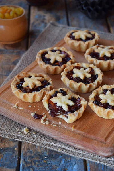 Mini Tartlets met gedroogde vruchten en noten. Shortbread koekjes met vruchten vulling op houten achtergrond. Kleine zoete taart. Kopiëren van ruimte. — Stockfoto