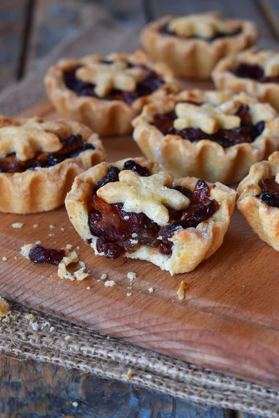 Mini Tartlets met gedroogde vruchten en noten. Shortbread koekjes met vruchten vulling op houten achtergrond. Kleine zoete taart. Kopiëren van ruimte. — Stockfoto