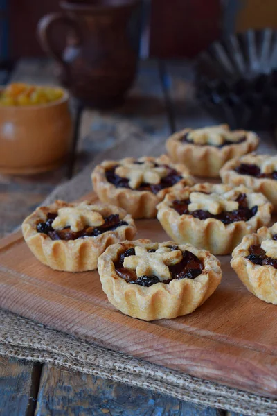 Mini Tartlets met gedroogde vruchten en noten. Shortbread koekjes met vruchten vulling op houten achtergrond. Kleine zoete taart. Kopiëren van ruimte. — Stockfoto
