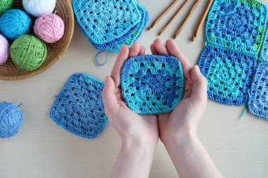 Örgü ve tığ işi kanca, renkli gökkuşağı pamuk ipliği, topu iş parçacığı, yün, örgü öğeleri, peçete donatımı. Büyükanne Meydanı. El yapımı el sanatları tığ. DIY kavramı. Kopya alanı