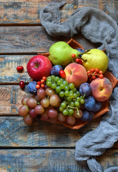 Осенний натюрморт на День благодарения с осенними фруктами и ягодами на деревянном фоне - виноград, яблоки, сливы, вибурнум, догвуд. Сырая еда. Копирование пространства — стоковое фото