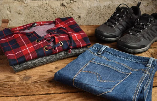 Män casual outfit. Mäns skor, kläder och accessoarer på trä bakgrund - tröja, jeans, sneakers. Ovanifrån. Lekmanna-platt — Stockfoto