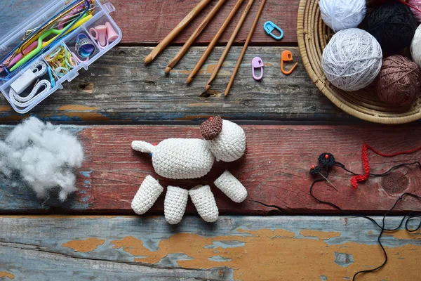 かぎ針編みの白い犬を作る。赤ちゃんや小物のためのおもちゃ。テーブルの糸、針、フック、綿糸の上に。手作りの贈り物。趣味からの収入。DIYクラフトのコンセプト。ステップ1 - おもちゃのすべての詳細を編みます. — ストック写真