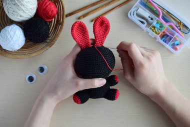 Tığ işi voodoo tavşan yapmak. Cadılar Bayramı için oyuncak. Masa iplikleri, kanca, pamuk iplik. El yapımı bir hediye. Mistik, gizli, korku Diy el sanatları kavramı. Adım 2 - oyuncak tüm detayları dikmek için.