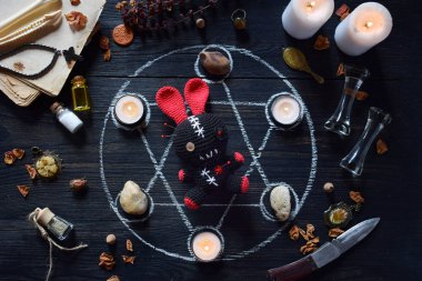 Voodoo tavşan iğneler dikilmiş vardır. Mumlar, pentagram, taşlar, aşk iksiri ve cadı masasında eski kitaplar. Gizli, ezoterik veya kehanet kavramı. Mistik, Cadılar Bayramı ve vintage arka plan