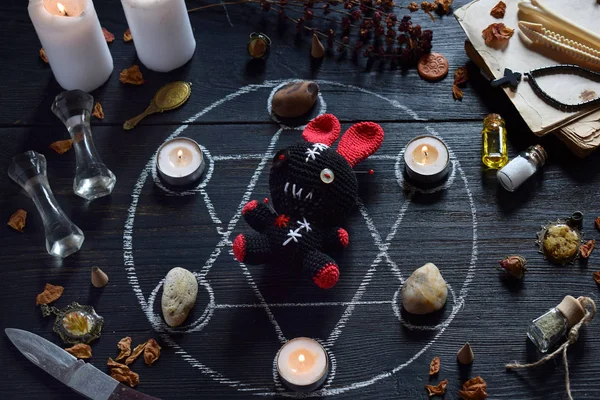 I Voodoo kanin är nålar prickade. Ljus, Pentagram, stenar, kärlek Potion och gamla böcker på Witch Table. Ockult, esoteriska eller spådom Concept. Mystic, Halloween och Vintage bakgrund — Stockfoto