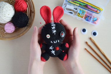 Making crochet voodoo rabbit. Toy for Halloween.  On the table threads, hook, cotton yarn. Handmade gift. Mystic, occult, horror DIY crafts concept. clipart