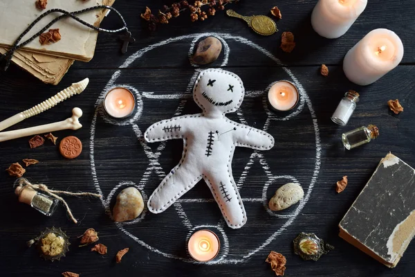 In Voodoo-Puppen werden Nadeln gestochen. Kerzen, Pentagramm, Steine, Liebestrank und alte Bücher auf dem Hexentisch. okkultes, esoterisches oder weissagerisches Konzept. Mystischer, halloween und vintage Hintergrund — Stockfoto