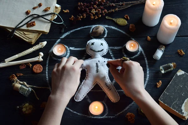 Voodoo bebek iğneler dikilmiş vardır. Mumlar, pentagram, taşlar, aşk iksiri ve cadı masasında eski kitaplar. Gizli, ezoterik veya kehanet kavramı. Mistik, Cadılar Bayramı ve vintage arka plan
