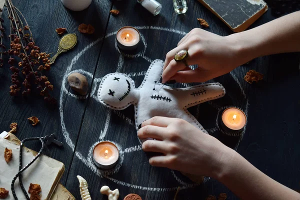 In Voodoo-Puppen werden Nadeln gestochen. Kerzen, Pentagramm, Steine, Liebestrank und alte Bücher auf dem Hexentisch. okkultes, esoterisches oder weissagerisches Konzept. Mystischer, halloween und vintage Hintergrund — Stockfoto