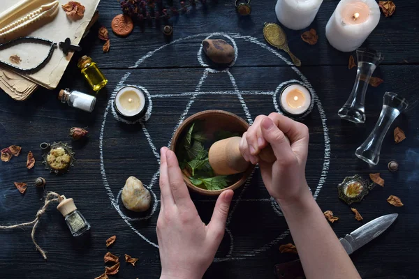 Las manos de mujer hacen poción de amor en el círculo de pentagrama con velas, piedras y libros antiguos en la mesa de brujas. Concepto oculto, esotérico o adivinación. Mística, Halloween y fondo vintage —  Fotos de Stock