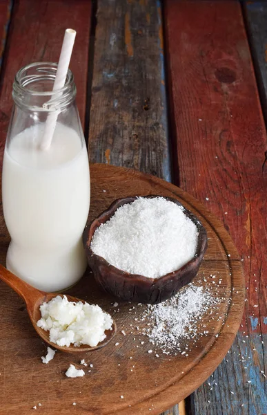 Leche de coco y aceite con coco roto sobre fondo de madera. Delicioso cóctel de leche. Copiar espacio . — Foto de Stock