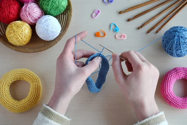 Maken van gehaakte piramide van gekleurde ringen. Speelgoed voor baby's en peuters om mechanische vaardigheden en kleuren te leren. Op de tabel draden, naalden, haak, garens van katoen. Handgemaakte ambachten. DIY concept. — Stockfoto