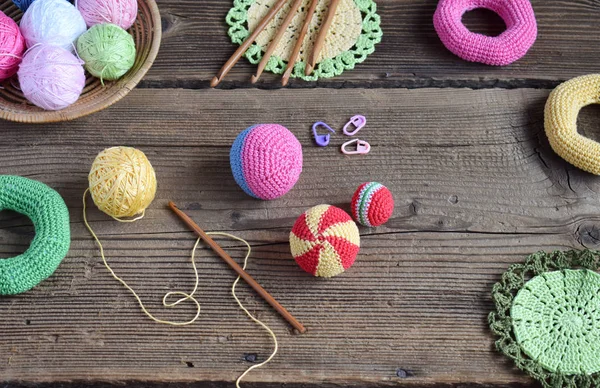 Making colored crochet balls. Toy for babies and toddlers to learn mechanical skills and colors. On the table threads, needles, hook, cotton yarn. Handmade crafts. DIY concept. — Stock Photo, Image