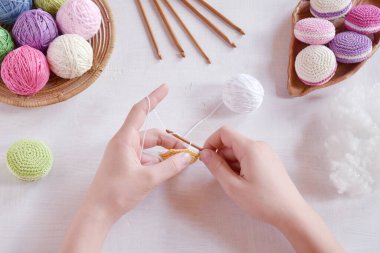 Tığ işi amigurumi Fransız badem kurabiyesi yapıyorum. Bebekler için oyuncak ya da incik boncuk. İplik, iğne, kanca, pamuk ipliği. El yapımı bir hediye. Hobiden gelir. DIY el işi konsepti. Adım 1 - tüm detayları örgü.