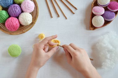 Tığ işi amigurumi Fransız badem kurabiyesi yapıyorum. Bebekler için oyuncak ya da incik boncuk. İplik, iğne, kanca, pamuk ipliği. El yapımı bir hediye. Hobiden gelir. DIY el işi konsepti. Adım 1 - tüm detayları örgü.