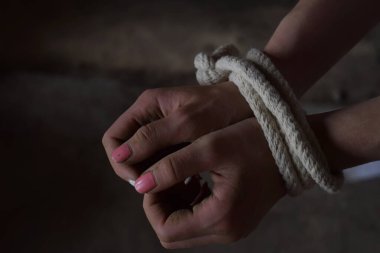 Kadın elleri iple bağlanmış, korkmuş, rehin alınmış, korkmuş. Kadınlara yönelik şiddeti, cinsel istismarı, aile içi şiddeti ve kaçakçılığı durdurun. İnsan Hakları Günü.